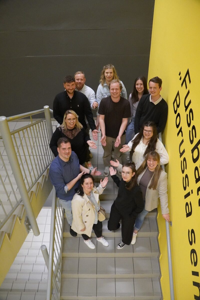 Gruppe junger Mitglieder der GdS-Jugend auf einer Treppe, die einladend nach vorne zeigen